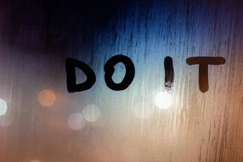 A command do it handwritten by finger on wet window glass at night with selec Photos