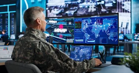 Commander Uses Computer And World Map To Plan Tactical Army Missions. Stock Photos
