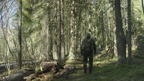 A commando in a mask and with a backpack moves through the forest. Stock-Footage 195228886