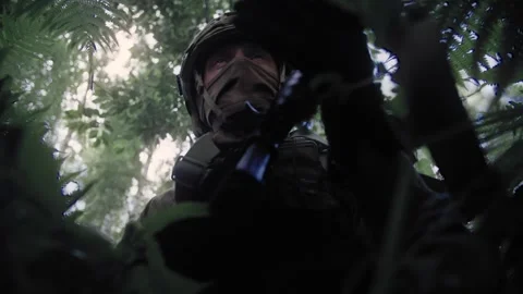 Commando sits in ambush in a dense deciduous forest Stock Footage 327350797