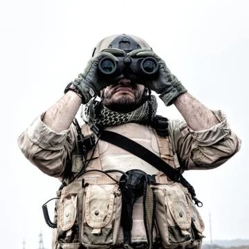Commando soldier using binoculars to observe terrain Stock Photos