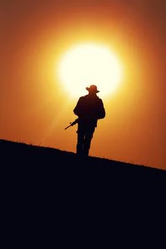 Commando soldier walking in desert at sunset Stock Photos