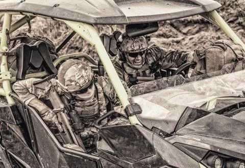 Commandos rush on fast attack vehicle in desert Foto stock