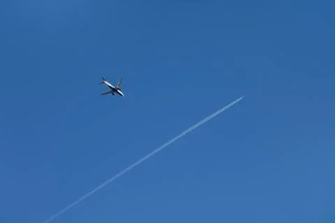 Commercial aircraft crossing paths over Halton Hills in a blue sky Stock Photos