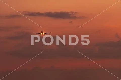Commercial airline. Passenger plane landing at airport with beautiful sunset Stock Photos