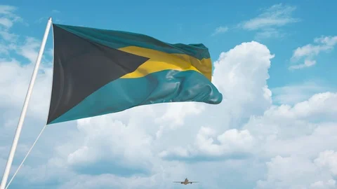 Commercial airplane landing behind the Bahamian flag. Tourism in Bahamas Stock Footage 123176644