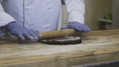 Commercial Bakery. Chef hands rolling out chocolate dough Stock Footage 78026911