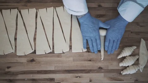 Commercial Bakery. A hand of a chef roll french bread croissant Stock Footage 78025673
