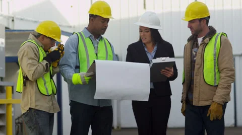 Commercial construction crew look over plans Stock Footage