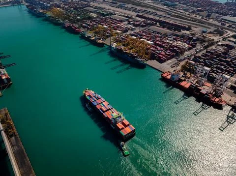 Commercial Container Vessel Navigating Through Busy Industrial Port Termina.. Stock Photos