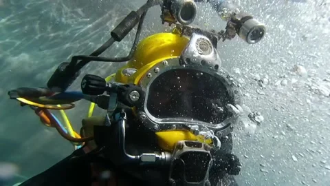 Commercial diver entering the water and wearing a diving helmet Stock Footage