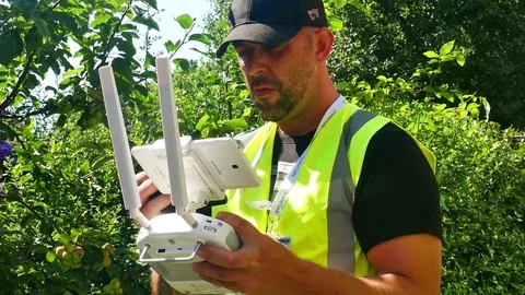 Commercial drone operator looking at controller Stock Footage 93461461