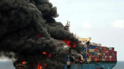 Commercial freight ship on fire burning in the ocean Stock Footage