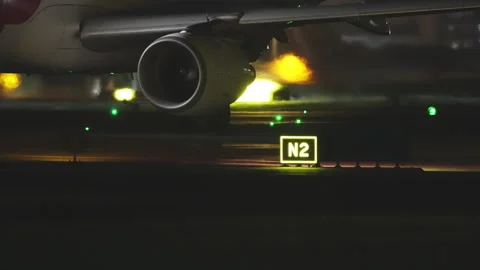 Commercial Jet Engine and Wing at Night with Glowing Runway Lights Stock Footage 346221108