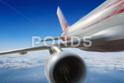 Commercial jet flies very fast in blue sky Stock Photos