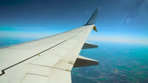 Commercial jet flying above patchy farmland. Passenger aircraft cruising over Stock Footage 329771217