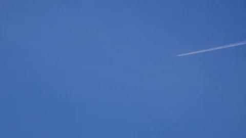 Commercial Jet leaves White Streak Across Blue Sky Stock Footage