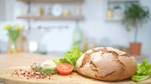 Commercial packshot with home baked bread and fresh greens at the table Stock Footage 107561228