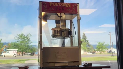 Commercial theater popcorn machine sits by window sunny day 스톡 동영상 339972453