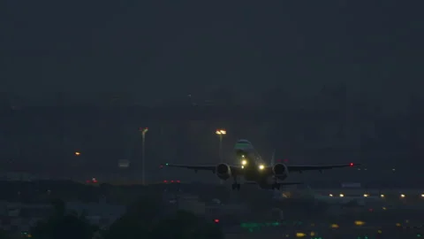 Commercial twin engine jet taking off at night over Madrid skyline Stock Footage 337798765
