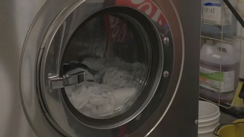 Commercial washing machine in progress, spinning drum, side angle. Stock Footage 101772917