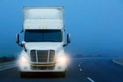Commerical Class 8 truck being driven in the fog on a country road. Stock Photos