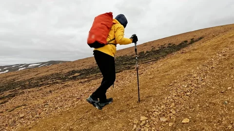 Commitment active young hiker woman in yellow jacket hiking on volcanic mou.. Stockbeeldmateriaal 237703836