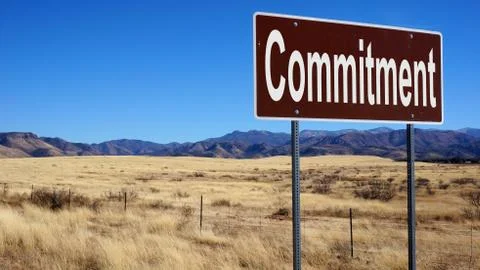 Commitment brown road sign Stock Photos