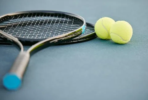Commitment gets you gold medals. two tennis rackets and tennis balls on a court Stock Photos