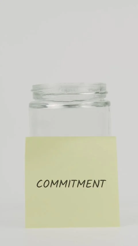 Commitment text or word on yellow sticky note attached to glass jar with Stock Footage 311694682