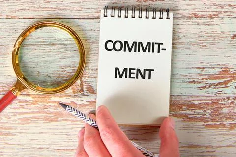 COMMITMENT Word Written on a blank sheet of notepad in a composition with a m Stock-Fotos