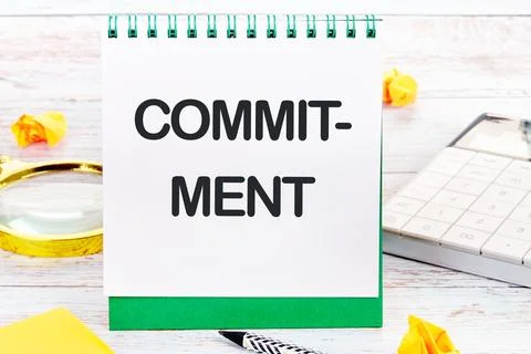 COMMITMENT Word Written on a blank sheet of a desktop notebook Stock-Fotos