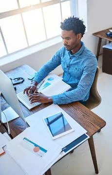 Committed to completed his work tasks. a young man using a computer at his work Stock Photos
