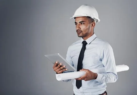 Committed to greatness and nothing less. a well-dressed civil engineer using his Stock Photos