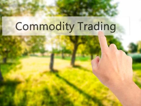 Commodity Trading - Hand pressing a button on blurred background concept . Bu Stock Photos