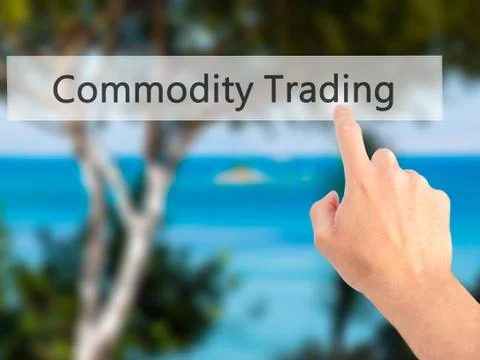 Commodity Trading - Hand pressing a button on blurred background concept . Bu Stock Photos