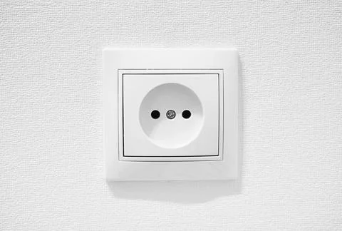 Common cheap plastic AC power wall socket. German circular recess socket with Stock Photos