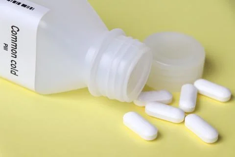Common cold pill in white bottle, pill stock Stockfoto's