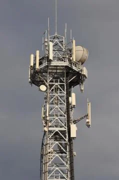 Communication cell tower against cloudy sky Stock Photos
