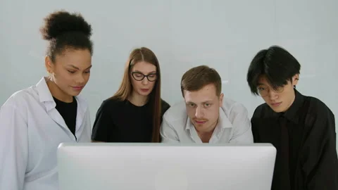Communication of four colleagues standing in front of a computer monitor Stock Footage 246052126