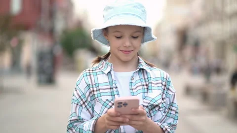 Communication girl looking message at cell phone or smartphone. Happy child Stock Footage 245731432