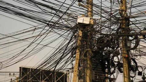 Communication lines that look cluttered on electrical poles, Look disorganized. Stock Photos