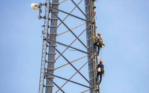 Communication maintenance. Two technicians climbing on telecom tower antenna Stock-Fotos