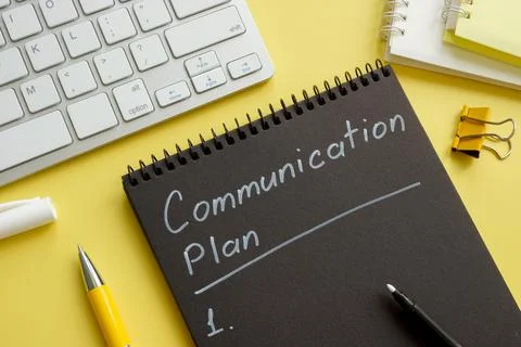 Communication plan on the open black notebook. Stock Photos