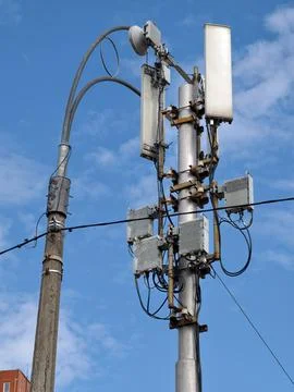 A communication pole with a cellular tower next to a streetlight at the sid.. Stock Photos