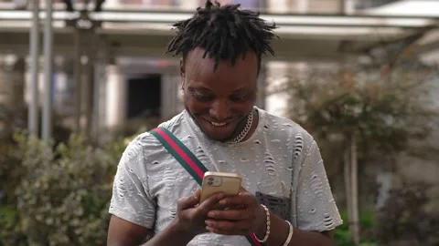 Communication, technology: Black man writing a message on his smartphone Stock Footage 218601293