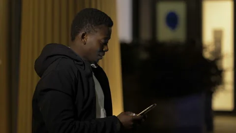 Communication, technology - confident black man types on phone to read messages Stock Footage 147323407