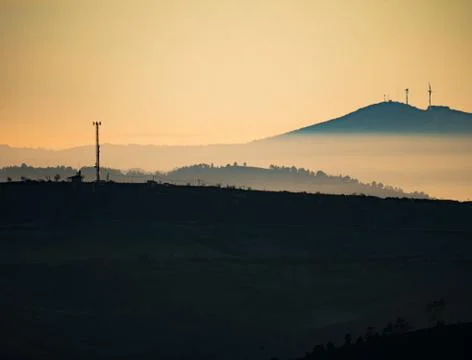 Communication tower backlit at dusk over the mountain Stock-Fotos