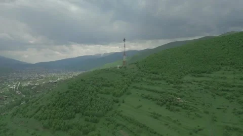 Communication tower, green forest, snowy mountains in cloudy weather. Armenia. Stock Footage 254280079