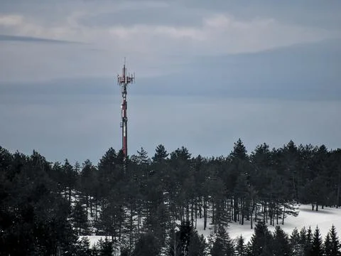 Communication tower in a mountain forest covered with snow Stock Photos